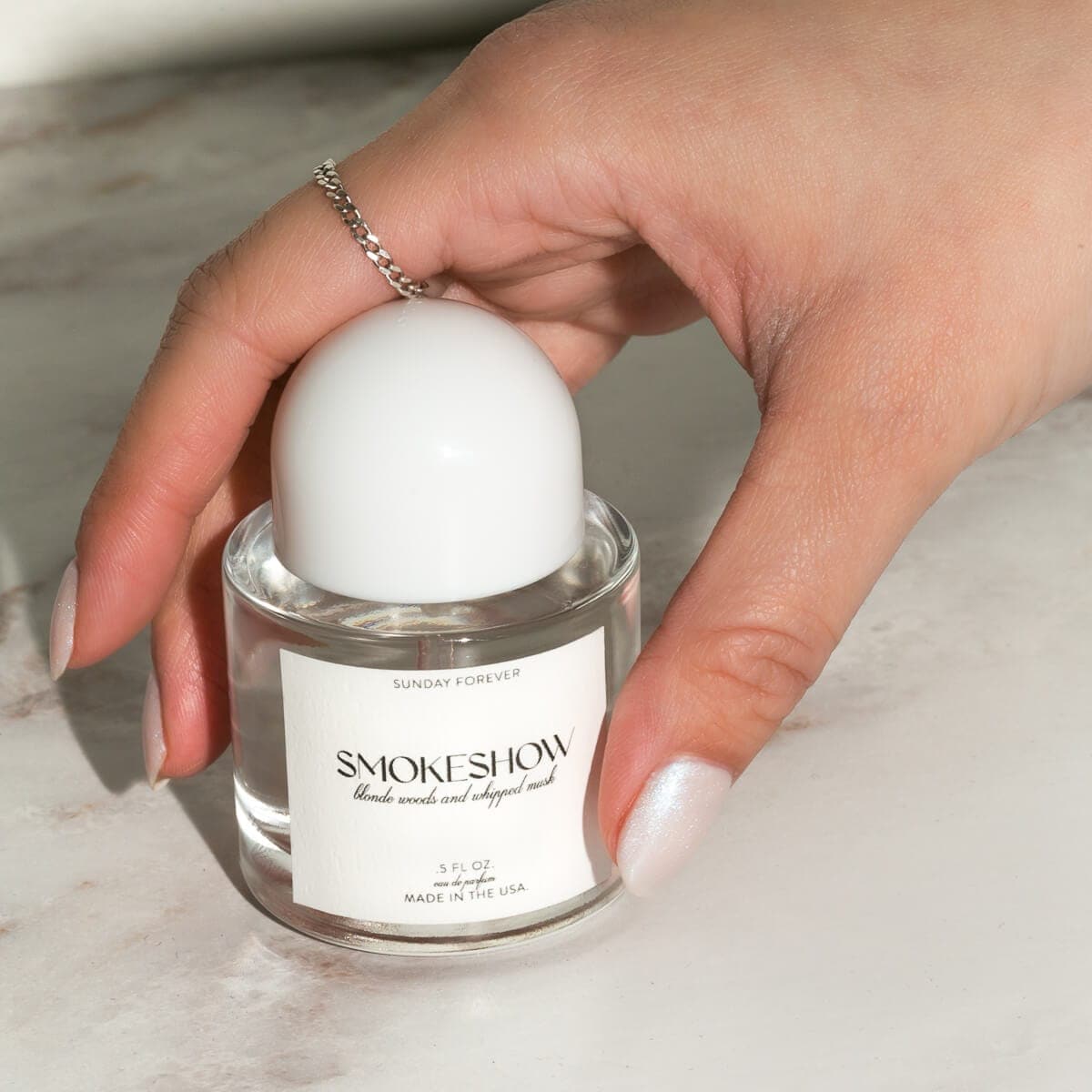 Smokeshow eau de parfum in a 1 oz bottle with a white round cap by Sunday Forever