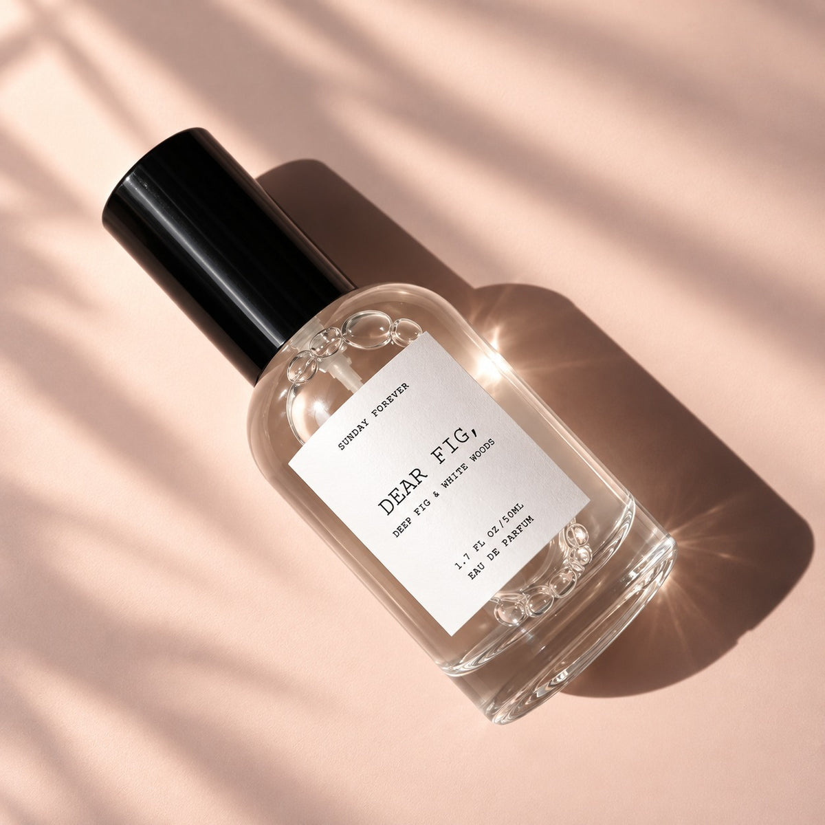 Dear Fig, Eau de Parfum lying flat on a blush background by Sunday Forever