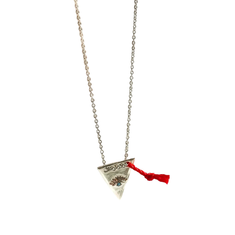 Necklace with a pyramid-shaped pendant and red ribbon on a light background